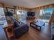 Well-lit living room with nice furniture, TV and ocean view from the balcony at 9820 Queensway Blvd. # 109, Myrtle Beach, SC 29572