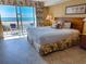 Bright main bedroom offers a large window with ocean view and a floral-patterned bedspread at 9820 Queensway Blvd. # 109, Myrtle Beach, SC 29572