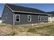 Exterior shot of the house's rear with siding, windows, and a covered back porch at 1013 Jase Dr., Longs, SC 29568