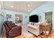 Cozy living room with a ceiling fan, a large TV, and a doorway to a sunroom at 105 Sebring Ln., Myrtle Beach, SC 29588