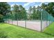 Community tennis court surrounded by a tall green fence and lush green trees at 105 Sebring Ln., Myrtle Beach, SC 29588