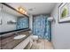 Bright bathroom with granite countertop, patterned shower curtain, and tiled floor at 107 S Ocean Blvd. # 1706, Myrtle Beach, SC 29577