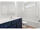 Modern bathroom featuring a vanity with deep blue cabinets, a toilet, and a bathtub with a shower at 119 Old Chimney Ln, Conway, SC 29526