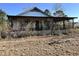 A quaint home featuring a covered porch enclosed by lattice, showcasing weathered charm and overgrown foliage at 1264 Harrelson Dr., Longs, SC 29568