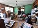 A living room filled with clutter and cardboard boxes, showing hardwood flooring and a classic chandelier at 1264 Harrelson Dr., Longs, SC 29568