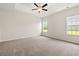 The main bedroom has a ceiling fan, carpeting, and natural light from two windows at 127 Old Chimney Ln, Conway, SC 29526