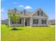 Charming single-story home with gray siding, black shutters, and a beautifully landscaped front yard at 127 Old Chimney Ln, Conway, SC 29526
