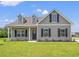 Charming single-Gathering home featuring a covered porch, dormer windows, and well-maintained landscaping at 127 Old Chimney Ln, Conway, SC 29526