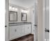 Well-lit bathroom featuring double sinks, granite countertops, and wood-look flooring at 130 Palm Dr., Loris, SC 29569