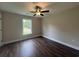 This bedroom features hardwood floors, neutral walls, a ceiling fan and a bright window at 130 Palm Dr., Loris, SC 29569
