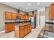 Well-lit kitchen with stainless steel appliances, brown cabinetry, island, and granite countertops at 169 Northside Dr., Little River, SC 29566