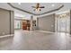 Open layout displaying tile floors, tray ceiling, ceiling fan, and partial view of the kitchen at 169 Northside Dr., Little River, SC 29566