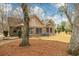 Backyard of home featuring a brick exterior, brown grass, and multiple trees with a blue rain barrel on the side of the house at 20 Brassie Dr., Carolina Shores, NC 28467