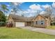 Brick house featuring an attached garage, well-kept lawn, and charming architectural details under a cloudy sky at 20 Brassie Dr., Carolina Shores, NC 28467