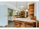 Bright kitchen features granite countertops, wood cabinets, modern lighting, and seating at the peninsula bar at 20 Brassie Dr., Carolina Shores, NC 28467