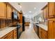 Well-lit kitchen boasting wooden cabinetry, granite countertops, sleek black appliances, and an open floor plan at 20 Brassie Dr., Carolina Shores, NC 28467