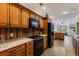 Spacious kitchen with wooden cabinetry, black appliances, and an open layout leading to a dining area at 20 Brassie Dr., Carolina Shores, NC 28467