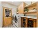 Well-organized laundry room with a full size washer and dryer, wooden cabinets, granite countertops and a glass panel door at 20 Brassie Dr., Carolina Shores, NC 28467