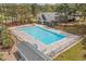 Aerial view of a community swimming pool with surrounding lounge chairs and lush greenery at 20 Brassie Dr., Carolina Shores, NC 28467