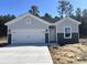 Charming single-Gathering home featuring a two-car garage, light gray siding and well-maintained landscaping at 264 Palmetto Sand Loop, Conway, SC 29527