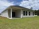 The back exterior of this home features a covered patio with sliding glass doors and a spacious lawn at 264 Palmetto Sand Loop, Conway, SC 29527