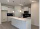 Beautiful kitchen with white cabinets, an island with counter seating, stylish pendants, and stainless steel appliances at 264 Palmetto Sand Loop, Conway, SC 29527