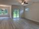 Open living room features light wood-look flooring, patio access and a view of the wooded backyard at 264 Palmetto Sand Loop, Conway, SC 29527