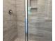 Modern tiled shower featuring neutral tile, glass surround, and convenient built-in shower storage shelves at 264 Palmetto Sand Loop, Conway, SC 29527