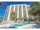 Large condo building featuring a pool and surrounding foliage at 311 69Th Ave. N # 505, Myrtle Beach, SC 29572