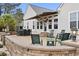 A luxurious stone patio featuring an awning, outdoor seating, and serene backyard views at 320 Esher Ct., Myrtle Beach, SC 29579