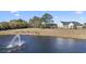 The home sits next to a scenic pond with a fountain and lush green landscaping at 320 Esher Ct., Myrtle Beach, SC 29579