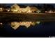 Backyard of the house reflecting on the water at nighttime and lit by the outdoor lights at 320 Esher Ct., Myrtle Beach, SC 29579