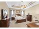 This primary bedroom includes a tray ceiling, fan, and neutral carpet at 320 Esher Ct., Myrtle Beach, SC 29579