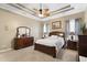 This spacious bedroom features a tray ceiling, ceiling fan, and elegant wood furniture at 320 Esher Ct., Myrtle Beach, SC 29579