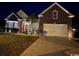 Well-lit home exterior with a brick facade, two-car garage, and manicured lawn at nighttime at 320 Esher Ct., Myrtle Beach, SC 29579