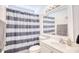 Well-lit bathroom featuring a navy striped shower curtain, white vanity, and modern mirror at 3964 Lochview Dr., Myrtle Beach, SC 29588