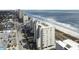 An aerial view capturing a condo, parking area, nearby beach, and the stunning ocean coastline at 4301 S Ocean Blvd. # 1-B, North Myrtle Beach, SC 29582