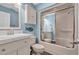 Bathroom featuring a white vanity, framed mirror, toilet, and tub-shower combo with glass doors at 435 Ocean Creek Dr. # 2705, Myrtle Beach, SC 29572