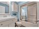 Bright bathroom featuring a vanity with a marble countertop and a shower with glass sliding doors at 435 Ocean Creek Dr. # 2705, Myrtle Beach, SC 29572