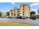 Low angle view of a yellow, multi-story condo building with a parking lot and neatly maintained landscaping at 601 N Hillside Dr. # 2331, North Myrtle Beach, SC 29582