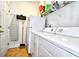 Laundry room equipped with a washer, dryer, refrigerator, storage shelves, and an ironing board with door access at 6095 Catalina Dr. # 1614, North Myrtle Beach, SC 29582