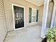 A welcoming front porch featuring a black front door, green shutters, and a small garden at 721 Painted Bunting Ct. # C, Murrells Inlet, SC 29576