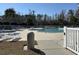 Community pool featuring a nearby hot tub, with tables, chairs, and a white fence at 721 Painted Bunting Ct. # C, Murrells Inlet, SC 29576