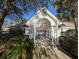 Inviting clubhouse entrance with white columns, mature landscaping, and iron gate at 80-2 Knight Circle # 2, Pawleys Island, SC 29585