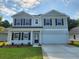 Charming two-story home with a manicured lawn and a two-car garage, under a sky with light clouds at 918 Agostino Dr., Myrtle Beach, SC 29579