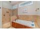Bright bathroom featuring a soaking tub and separate shower, tiled walls, and natural light from two windows at 921 Heshbon Dr., North Myrtle Beach, SC 29582