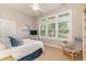 Bright bedroom featuring a bed, sitting chair, and natural light from three large windows at 921 Heshbon Dr., North Myrtle Beach, SC 29582