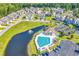 Drone's eye view of community pool, pond with fountain, ample parking, and surrounding residential buildings at 940 Jackline Place # 202, Murrells Inlet, SC 29576