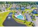 Aerial view of the community pool, clubhouse, pond, and surrounding townhomes on a sunny day at 940 Jackline Place # 202, Murrells Inlet, SC 29576