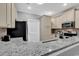 Well-lit kitchen featuring stainless steel appliances, granite countertops, tile backsplash and custom cabinetry at 940 Jackline Place # 202, Murrells Inlet, SC 29576